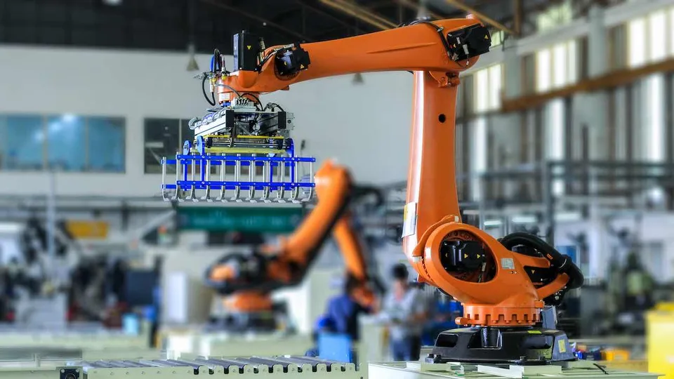 Orange industrial robot arm on a factory production line